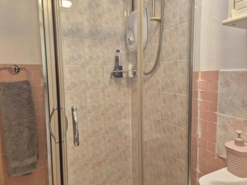 a shower with a glass door in a bathroom at Glams one bedroom apartment in Wolverhampton