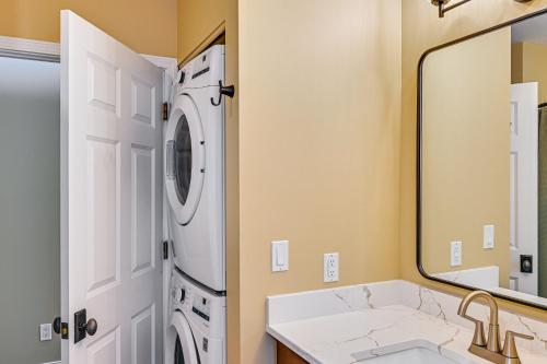 a bathroom with a washing machine and a sink at 'Phoenix Nest' South Haven Condo: River View! in South Haven