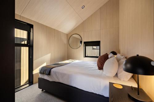 a bedroom with a bed and a desk with a lamp at Wakatipu Villa, Queenstown in Queenstown