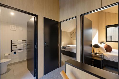 a room with a bathroom with a toilet and a bed at Wakatipu Villa, Queenstown in Queenstown