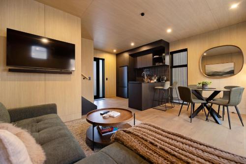 a living room with a couch and a table at Wakatipu Villa, Queenstown in Queenstown