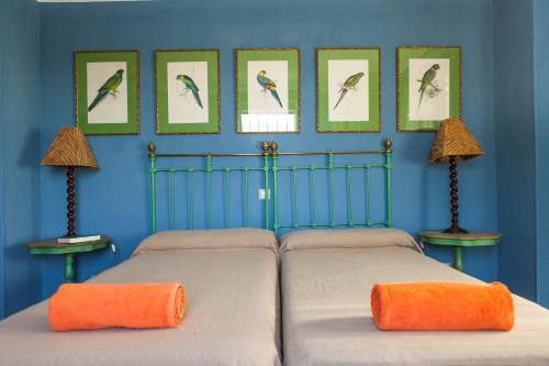 a bedroom with two beds and pictures of birds on the wall at Caseria San Jose in Bobadilla