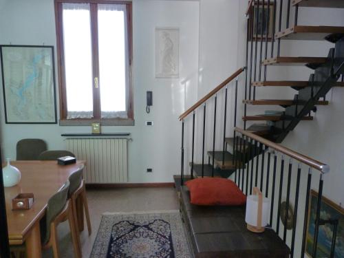 a living room with a staircase and a table at Appartamento Lago Maggiore in Arona