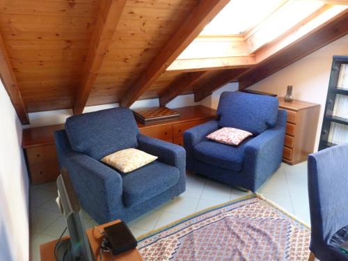 a room with two blue chairs and a window at Appartamento Lago Maggiore in Arona
