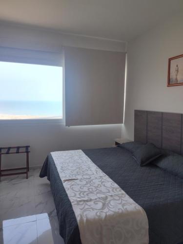 a bedroom with a large bed and a window at Sol y mar in Boca del Río