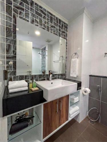 a bathroom with a white sink and a mirror at Dusit Grand Park - Modern Studio Pool View in Jomtien Beach