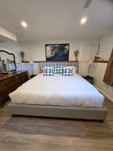 a bedroom with a large white bed with blue pillows at Rustic Guest Suite in Ucluelet