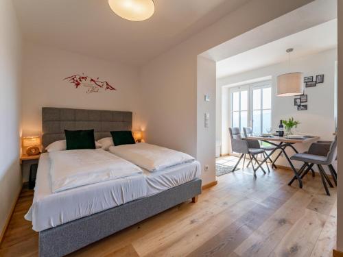 a bedroom with a bed and a table and chairs at Lärchenhof Top 01 in Mauterndorf