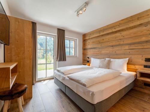 a bedroom with a large bed and a wooden wall at Wagrainer TauernLodge 42A in Wagrain
