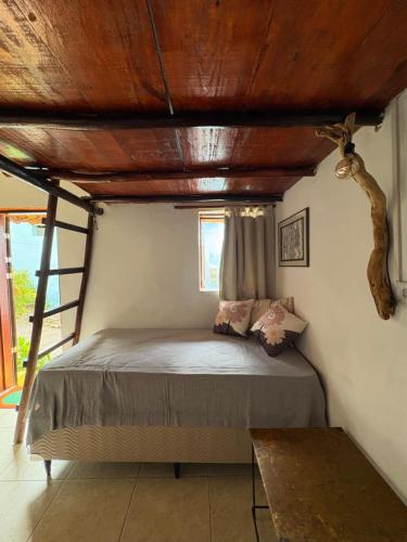 a bedroom with a bed with a wooden ceiling at Casa Ametista in Lençóis