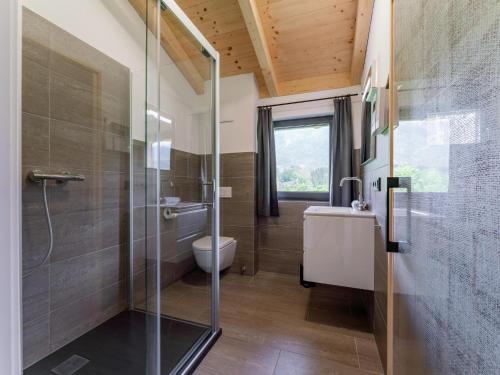 a bathroom with a shower and a toilet and a sink at Sauna Chalet 9B in Obermöschach