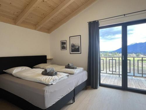 a bedroom with two beds and a balcony at Sauna Chalet 9B in Obermöschach