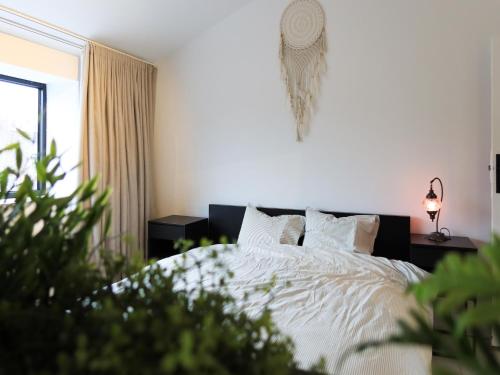 a bedroom with a bed with white sheets and pillows at Cosy Courtyard House Hasselt in Hasselt