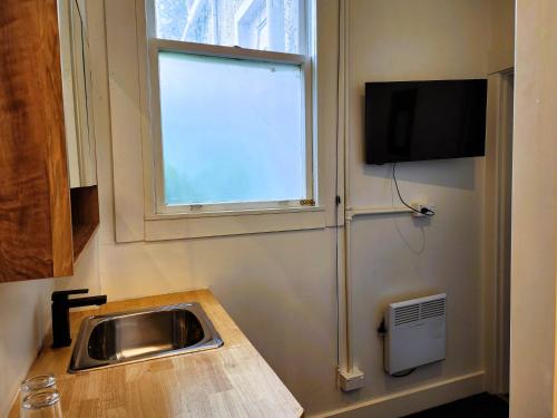 a kitchen with a sink and a window at Urban Lounge Sleepery Carterton in Carterton
