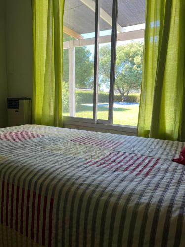 a bedroom with a bed and a large window at La Calma Casa Quinta in Tandil