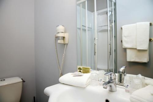 a bathroom with a sink and a mirror at The Originals City, Hôtel Le Causséa, Castres in Castres