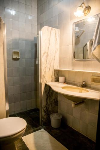 a bathroom with a sink and a toilet and a mirror at Pousada e Espaço Flor da Serra in Cruzeiro