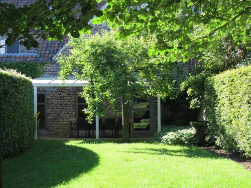 a house with a garden and a yard with trees at d'Uyterwaerde in Leut