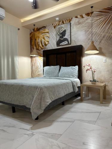 a bedroom with a large bed and a table at Ancla Suites in Puerto Peñasco