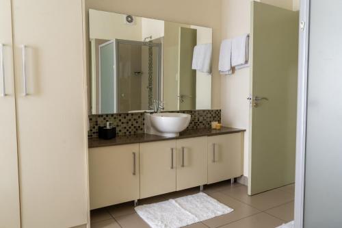 a bathroom with a sink and a large mirror at Ngalufuno-wlove in Johannesburg