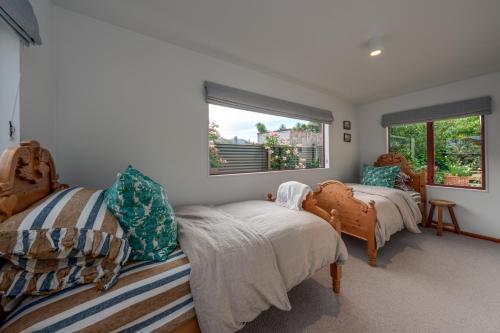 a bedroom with two beds and a window at Stone Street Cottage by Sothebys Luxury Rental Homes in Wanaka