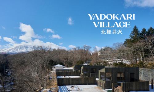 a picture of a building with a mountain in the background at YADOKARI Village 北軽井沢 in Kita-karuizawa