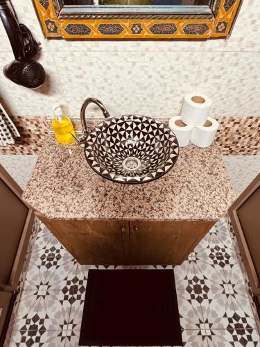 a bathroom counter with a sink and toilet paper at essaouira van hostel in Essaouira