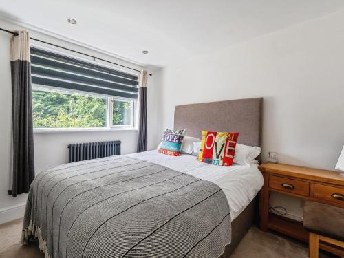 a bedroom with a large bed and a window at Mylnebeck Lodge in Windermere