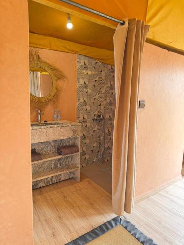 a bathroom with a sink and a mirror at Le Pacha Luxury Desert Camp - Mhamid Sahara Activities in Mhamid