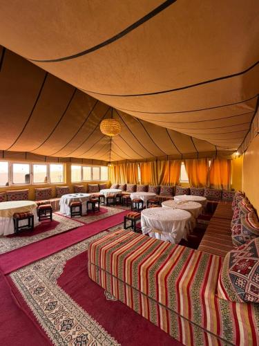 a tent with tables and chairs in a room at Le Pacha Luxury Desert Camp - Mhamid Sahara Activities in Mhamid
