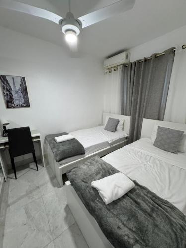 a room with two beds and a desk and a chair at Residencial christall ap 2-A in Santiago de los Caballeros