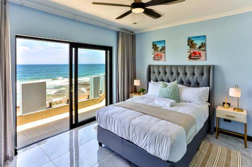 a bedroom with a bed with a view of the ocean at Villa Belle Mere Boutique Hotel in Sheffield Beach
