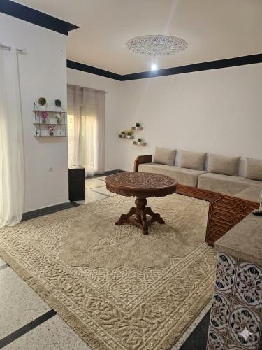 a living room with a table and a couch at Appartement 3S in Meknès