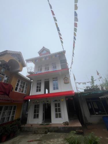 a white house with a red awning at Jojos homestay in Mirik