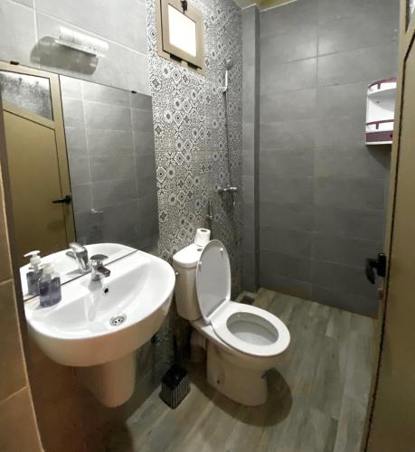 a bathroom with a white toilet and a sink at Blue Drift in Imsouane