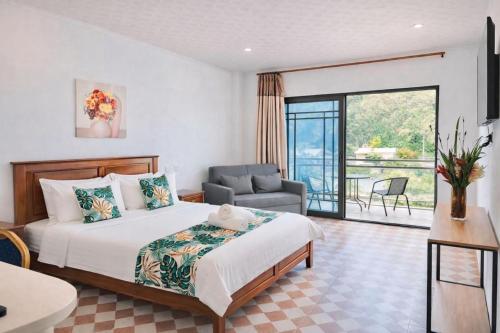 a bedroom with a bed and a chair and a balcony at Crown Royale Hotel & Lounge in Port Vila