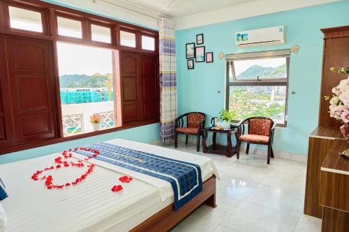 a bedroom with a bed with red flowers on it at Phoenix Flower Hotel in Cat Ba