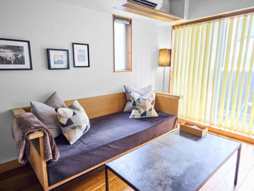 a living room with a couch and a glass table at Hotel Vintage Tokyo Tsukiji in Tokyo