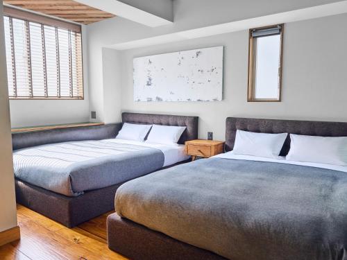 two beds sitting next to each other in a room at Hotel Vintage Tokyo Tsukiji in Tokyo