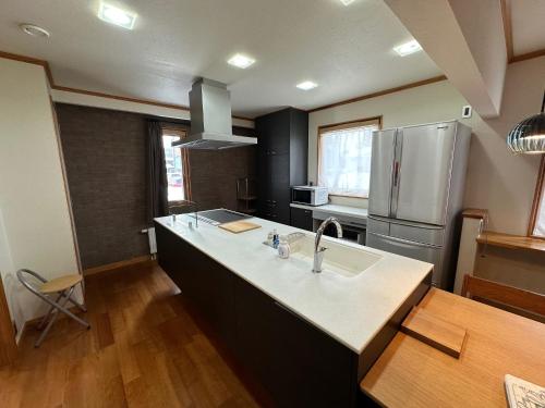 a kitchen with a sink and a refrigerator at Chalet Yutaka in Furano