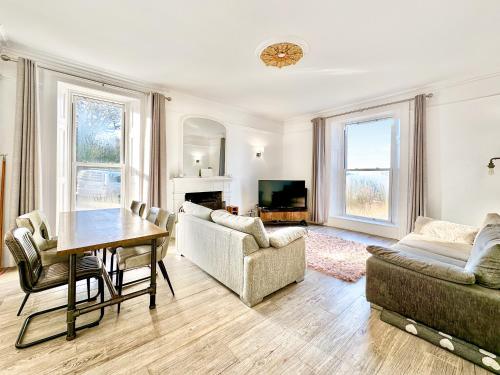 a living room with a table and a couch at Cedars in Mortehoe