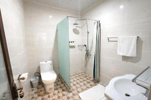 a bathroom with a shower and a toilet and a sink at Crown Royale Hotel & Lounge in Port Vila
