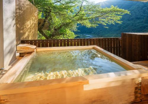 a hot tub on a deck with a view at Marumine Kanko Hotel in Aizuwakamatsu