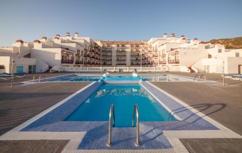 uma vista para uma piscina com edifícios ao fundo em Apartamentos Centro Cancajos em Los Cancajos