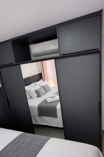 a bedroom with a bed and a mirror at Flat PREMIUM em Manaíra - Sun Beach in João Pessoa