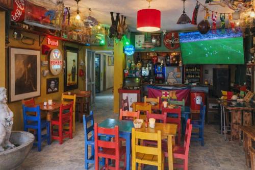 a restaurant with colorful chairs and tables and a tv at Casa Almarita Hostel Social Bar in Medellín