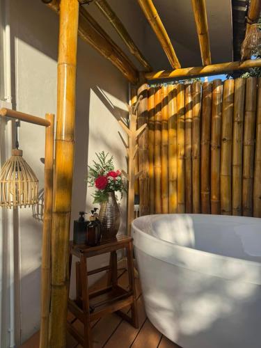 a bathroom with a tub and a table with flowers at Japanese house PhuSaimorkVilla in Ban Kai Noi