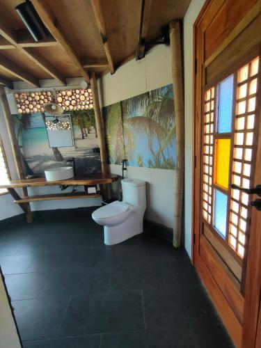 a bathroom with a toilet and a sink at Grandview Cottages Resort in Siaton