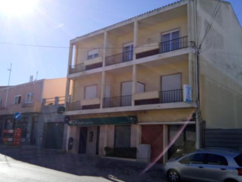 a building with a car parked in front of it at Alojamentos S.José in Atouguia da Baleia