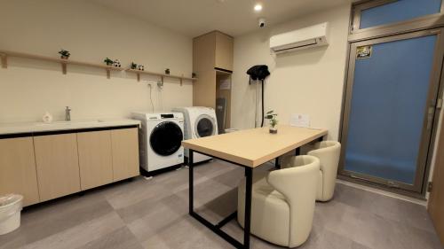 a kitchen with a table and a washing machine at Rest Collection Bentencho Osaka in Osaka